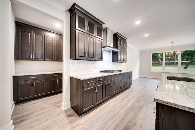 7266 Fairlawn Dr, Fairview, TN 37062 - kitchen with wall chimney range hood, stainless steel gas stovetop, light wood-style floors, light stone counters, and backsplash