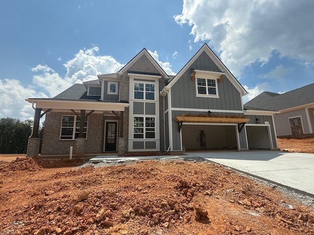 7266 Fairlawn Dr, Fairview, TN 37062 - view of front of home featuring board and batten siding, driveway, a garage, brick siding, and a porch