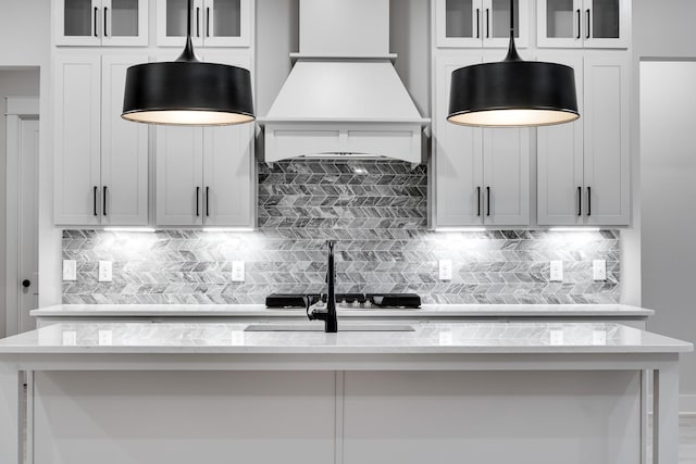 7233 Richvale Dr W, Fairview, TN 37062 - kitchen with premium range hood, hanging light fixtures, and glass insert cabinets