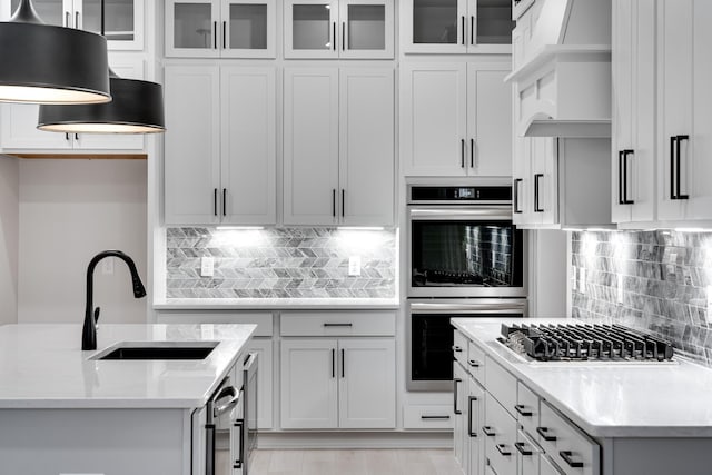 7233 Richvale Dr W, Fairview, TN 37062 - kitchen featuring appliances with stainless steel finishes, decorative backsplash, pendant lighting, glass insert cabinets, and white cabinetry