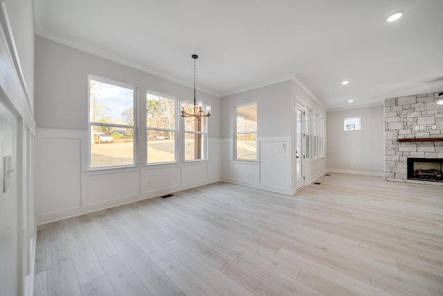 7233 Richvale Dr W, Fairview, TN 37062 - unfurnished living room featuring a chandelier, light wood-type flooring, a fireplace, a wainscoted wall, and healthy amount of natural light