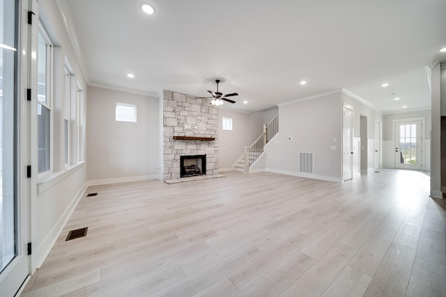 7233 Richvale Dr W, Fairview, TN 37062 - unfurnished living room featuring ornamental molding, ceiling fan, a fireplace, plenty of natural light, and light wood-type flooring