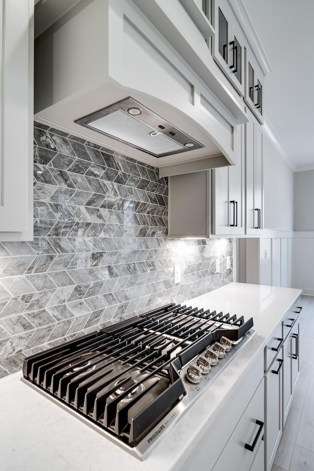 7233 Richvale Dr W, Fairview, TN 37062 - kitchen with stainless steel gas cooktop, light countertops, ornamental molding, tasteful backsplash, and premium range hood