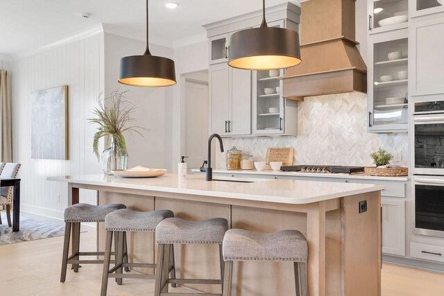 7428 Twill Heights Loop W, Fairview, TN 37062 - kitchen with stainless steel appliances, tasteful backsplash, light countertops, crown molding, and a center island with sink