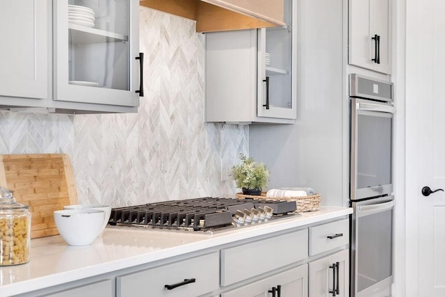 7428 Twill Heights Loop W, Fairview, TN 37062 - kitchen with stainless steel appliances, decorative backsplash, glass insert cabinets, light countertops, and white cabinetry