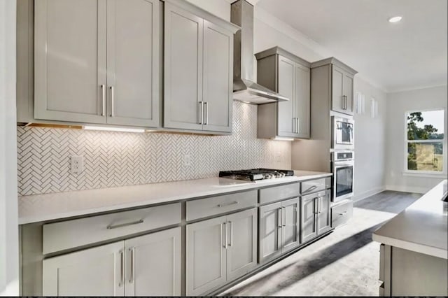 7262 Fairlawn Dr, Fairview, TN 37062 - kitchen featuring stainless steel appliances, gray cabinetry, wall chimney range hood, tasteful backsplash, and ornamental molding