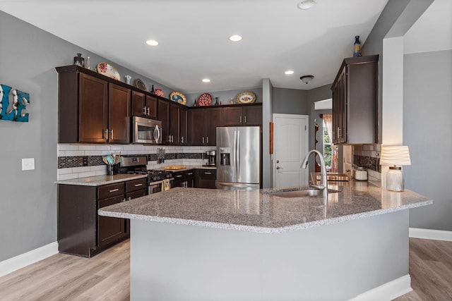 1301 Drury Ln, Mount Juliet, TN 37122 - kitchen featuring stainless steel appliances, dark brown cabinets, a peninsula, light stone counters, and recessed lighting