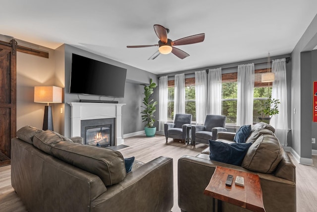 1301 Drury Ln, Mount Juliet, TN 37122 - living area featuring a barn door, wood finished floors, ceiling fan, and a fireplace with flush hearth