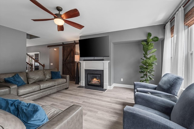 1301 Drury Ln, Mount Juliet, TN 37122 - living area featuring ceiling fan, light wood finished floors, a barn door, and a fireplace with flush hearth