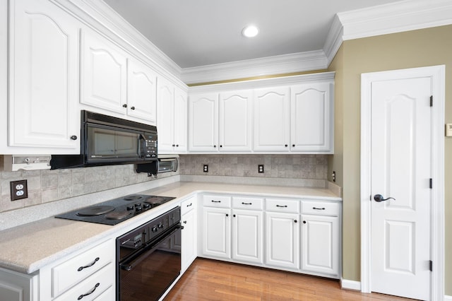 395 Glendower Pl, Franklin, TN 37064 - kitchen with black appliances, light wood-style floors, crown molding, white cabinetry, and light countertops