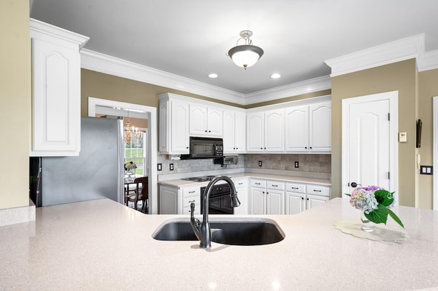 395 Glendower Pl, Franklin, TN 37064 - kitchen with black microwave, freestanding refrigerator, crown molding, white cabinets, and recessed lighting