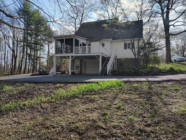 631 Mag A Mor Dr, Lafayette, TN 37083 - view of front of home featuring a sunroom, an attached garage, asphalt driveway, stairs, and a wooden deck