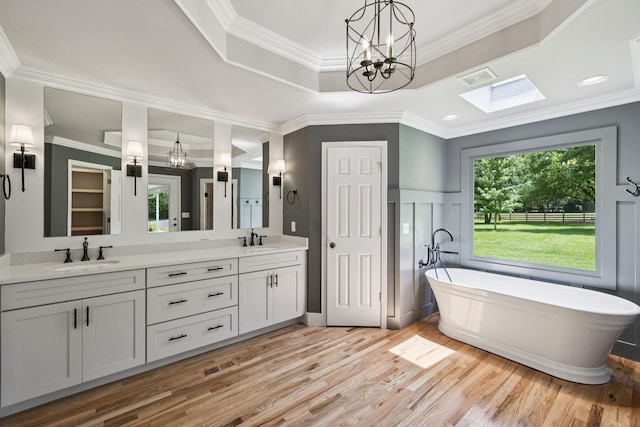 1061 Alford Rd, Murfreesboro, TN 37129 - full bathroom featuring a chandelier, double vanity, a freestanding bath, wood finished floors, and a skylight