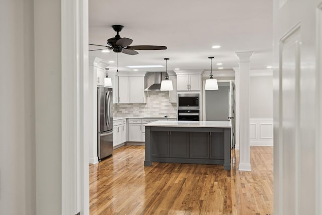 1061 Alford Rd, Murfreesboro, TN 37129 - kitchen with black appliances, wall chimney range hood, ceiling fan, light countertops, and light wood-style flooring