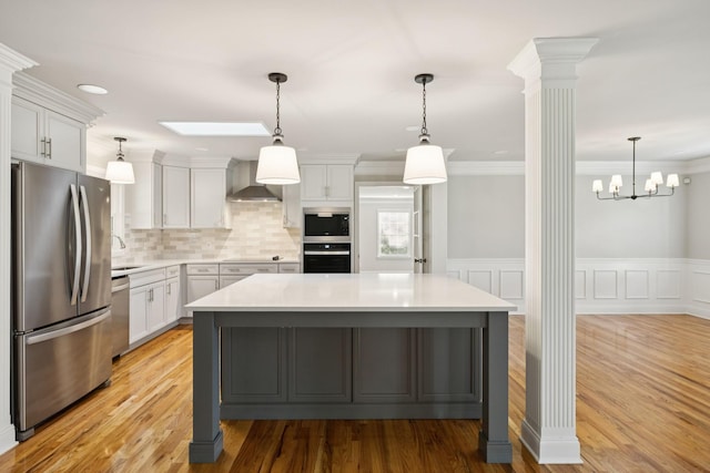 1061 Alford Rd, Murfreesboro, TN 37129 - kitchen with stainless steel appliances, decorative columns, wall chimney range hood, light countertops, and crown molding