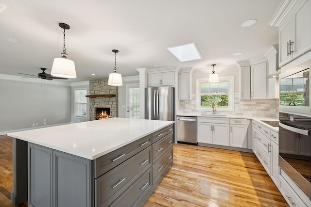 1061 Alford Rd, Murfreesboro, TN 37129 - kitchen featuring stainless steel appliances, gray cabinetry, a fireplace, backsplash, and white cabinets