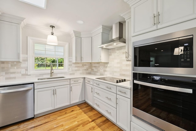1061 Alford Rd, Murfreesboro, TN 37129 - kitchen featuring appliances with stainless steel finishes, wall chimney range hood, light countertops, white cabinets, and hanging light fixtures