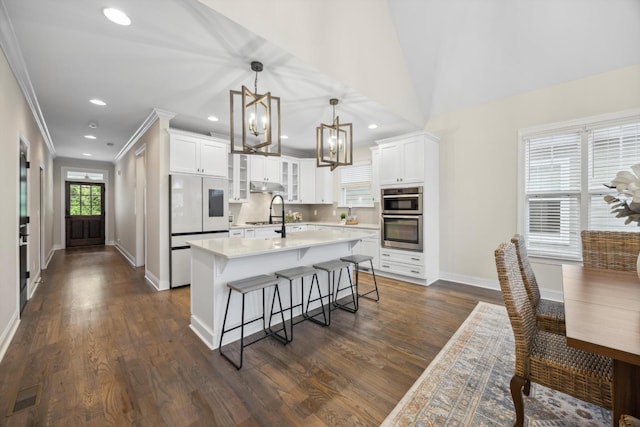 773 Curve St, Chattanooga, TN 37405 - kitchen featuring a chandelier, stainless steel double oven, a kitchen island with sink, a kitchen breakfast bar, and white cabinetry