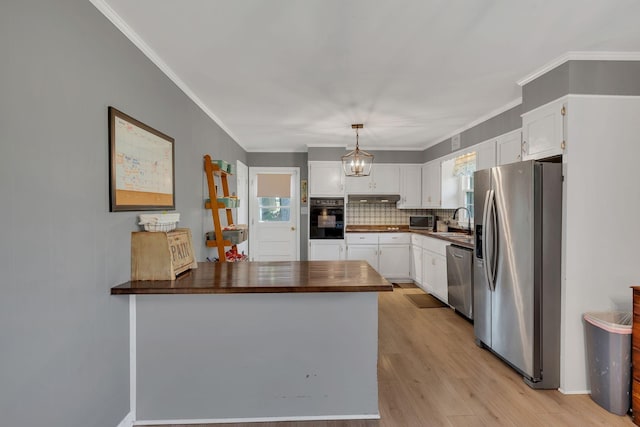 5058 New Chapel Rd, Springfield, TN 37172 - kitchen with appliances with stainless steel finishes, a peninsula, under cabinet range hood, white cabinets, and backsplash