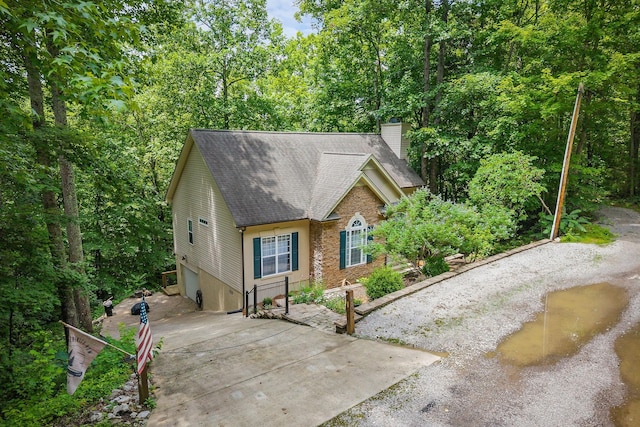 655 Lakeside Dr, Smithville, TN 37166 - view of front facade featuring a shingled roof, a chimney, an attached garage, and driveway