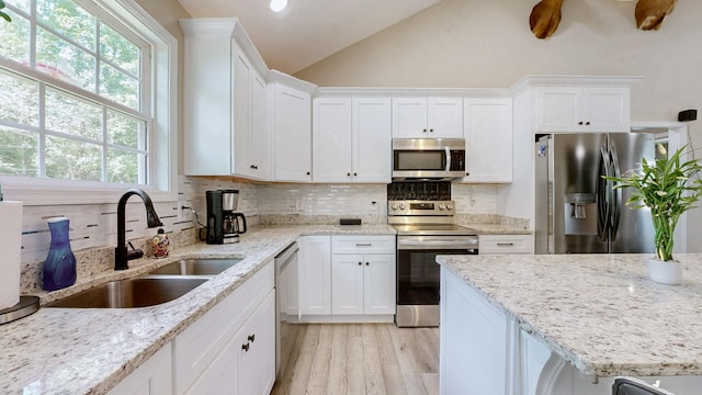 785 Grindstone Hollow Rd, Dickson, TN 37055 - kitchen with stainless steel appliances, white cabinetry, lofted ceiling, tasteful backsplash, and light stone counters