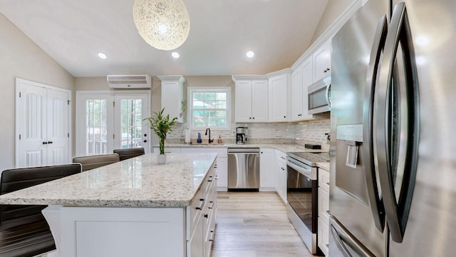 785 Grindstone Hollow Rd, Dickson, TN 37055 - kitchen featuring appliances with stainless steel finishes, a kitchen island, white cabinetry, decorative backsplash, and lofted ceiling
