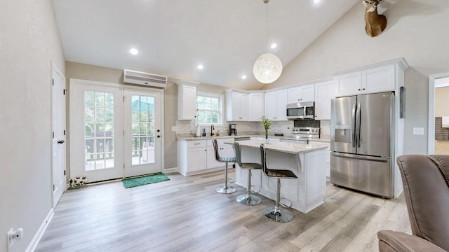785 Grindstone Hollow Rd, Dickson, TN 37055 - kitchen featuring appliances with stainless steel finishes, a breakfast bar area, backsplash, white cabinets, and a center island