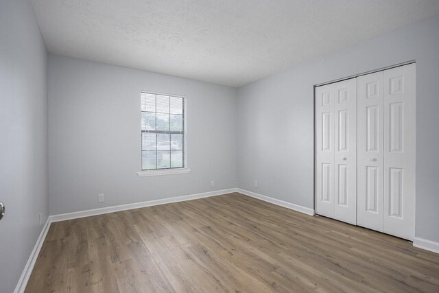 3332 Oak Trees Ct, Antioch, TN 37013 - unfurnished bedroom featuring wood finished floors, a textured ceiling, and a closet