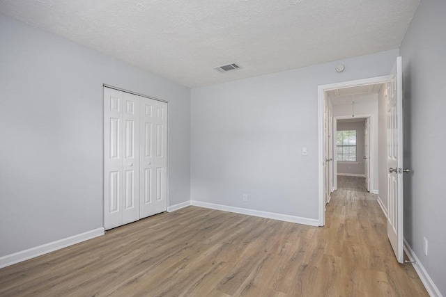 3332 Oak Trees Ct, Antioch, TN 37013 - unfurnished bedroom featuring attic access, light wood-type flooring, a textured ceiling, and a closet