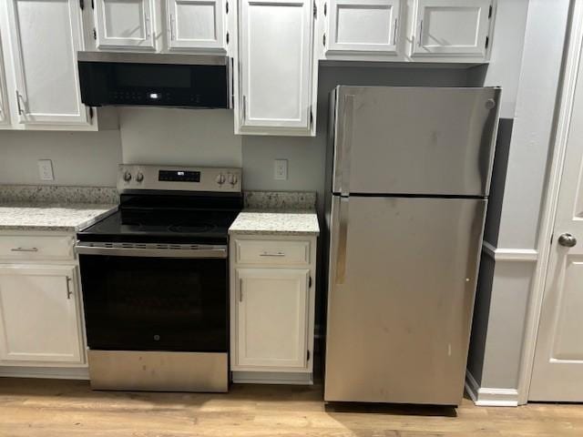 3332 Oak Trees Ct, Antioch, TN 37013 - kitchen with appliances with stainless steel finishes, light wood finished floors, light stone countertops, and white cabinets