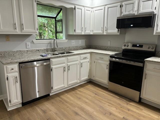 3332 Oak Trees Ct, Antioch, TN 37013 - kitchen with stainless steel appliances, light wood-style flooring, and white cabinets