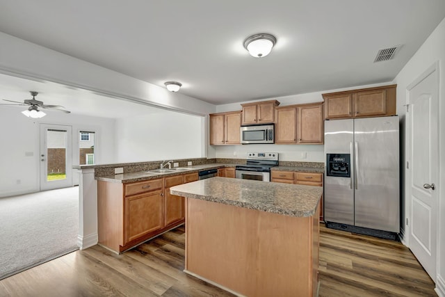 4247 Aurora Cir, Murfreesboro, TN 37127 - kitchen featuring stainless steel appliances, a peninsula, dark wood-style floors, and brown cabinets