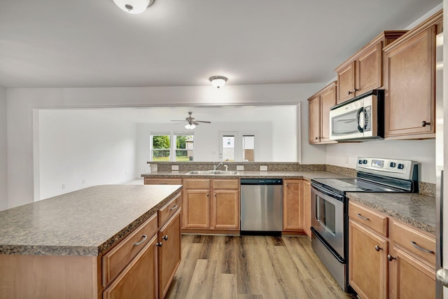 4247 Aurora Cir, Murfreesboro, TN 37127 - kitchen featuring appliances with stainless steel finishes, light wood finished floors, a peninsula, a ceiling fan, and dark countertops