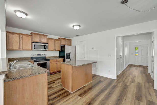 4247 Aurora Cir, Murfreesboro, TN 37127 - kitchen with appliances with stainless steel finishes, wood finished floors, a center island, stone countertops, and brown cabinets