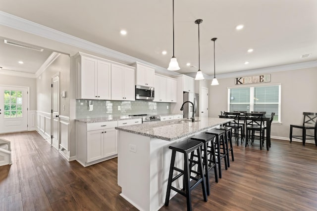 2529 Precast Dr, Columbia, TN 38401 - kitchen with appliances with stainless steel finishes, an island with sink, a breakfast bar area, white cabinets, and dark wood-type flooring