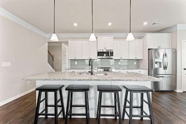 2529 Precast Dr, Columbia, TN 38401 - kitchen featuring stainless steel appliances, crown molding, decorative backsplash, white cabinetry, and a kitchen breakfast bar