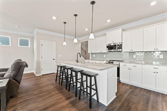 2529 Precast Dr, Columbia, TN 38401 - kitchen featuring appliances with stainless steel finishes, dark wood finished floors, a breakfast bar, decorative backsplash, and crown molding