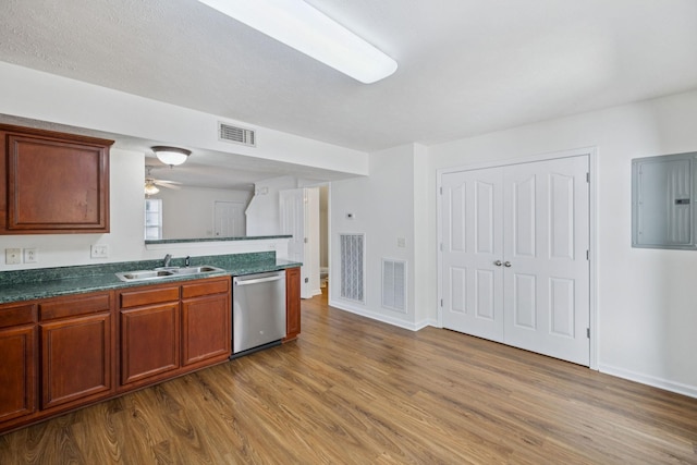 354 Arapaho Dr, Murfreesboro, TN 37128 - kitchen with stainless steel dishwasher, electric panel, light wood-type flooring, dark countertops, and a peninsula