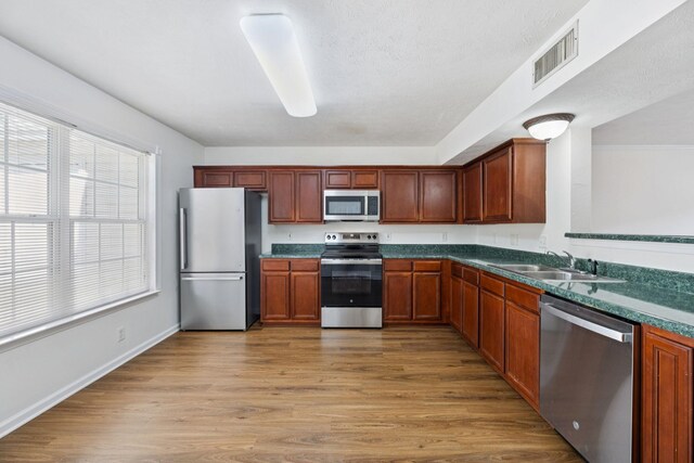 354 Arapaho Dr, Murfreesboro, TN 37128 - kitchen with stainless steel appliances, dark countertops, and light wood finished floors