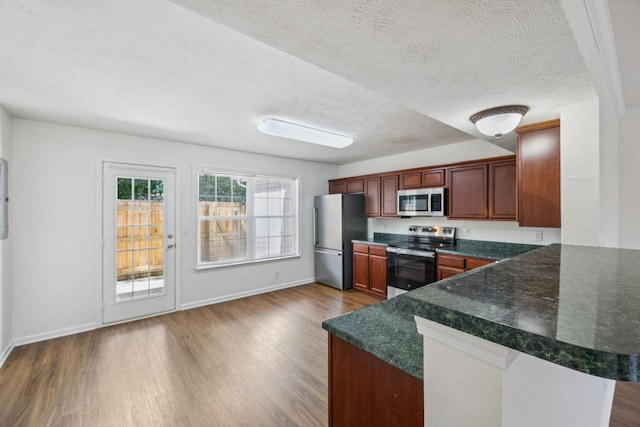 354 Arapaho Dr, Murfreesboro, TN 37128 - kitchen featuring stainless steel appliances, dark wood-style floors, a peninsula, and a textured ceiling
