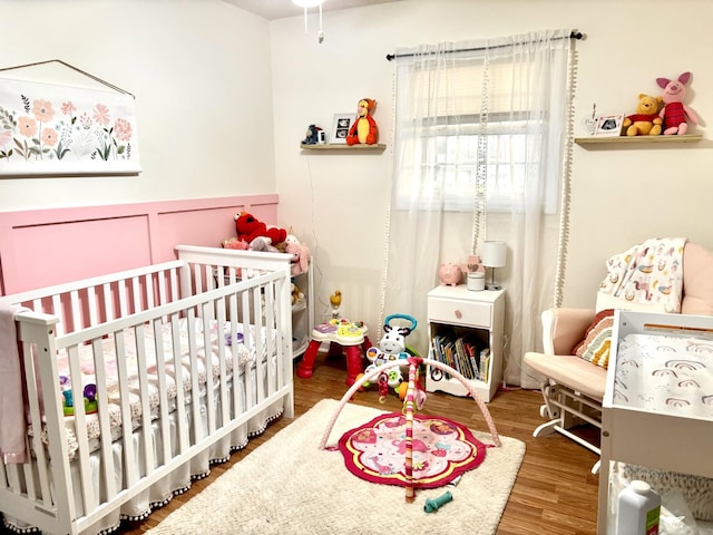 30429 Sims St, Ardmore, TN 38449 - bedroom featuring a crib, wood finished floors, and wainscoting