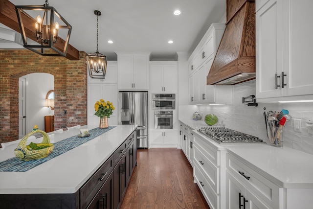 445 Old Pond Ln, Dickson, TN 37055 - kitchen featuring a chandelier, custom range hood, appliances with stainless steel finishes, light countertops, and dark wood-style flooring