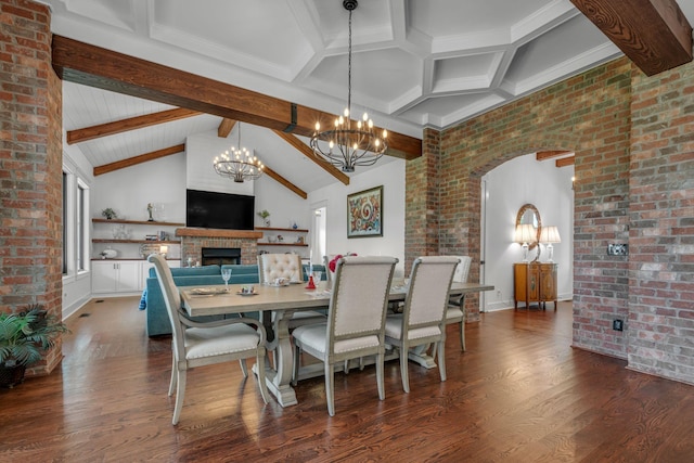 445 Old Pond Ln, Dickson, TN 37055 - dining area featuring a chandelier, dark wood-style flooring, a fireplace, brick wall, and arched walkways