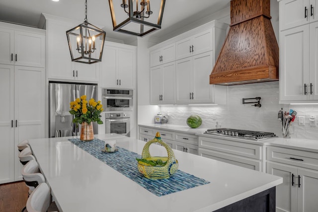 445 Old Pond Ln, Dickson, TN 37055 - kitchen with premium range hood, appliances with stainless steel finishes, a chandelier, white cabinetry, and light countertops