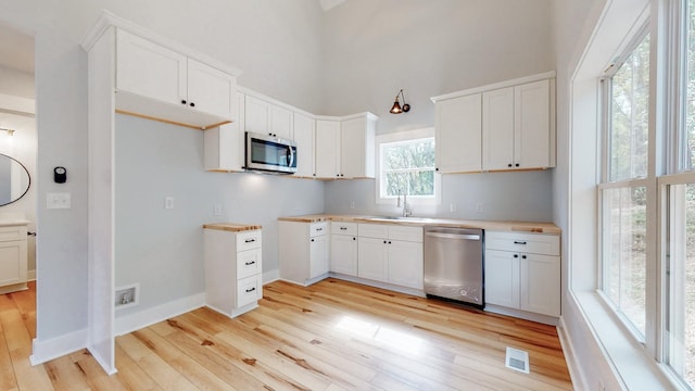 2346 Rhea Branch Rd, Ethridge, TN 38456 - kitchen with appliances with stainless steel finishes, light wood finished floors, a towering ceiling, and white cabinets
