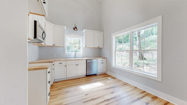 2346 Rhea Branch Rd, Ethridge, TN 38456 - kitchen with stainless steel appliances, light wood-style flooring, light countertops, a high ceiling, and white cabinetry