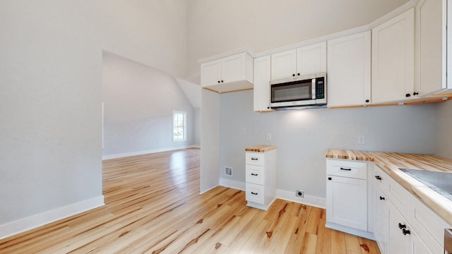 2346 Rhea Branch Rd, Ethridge, TN 38456 - kitchen with stainless steel microwave, light wood finished floors, light countertops, white cabinets, and a towering ceiling