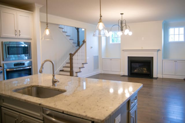 1023 Echelon Dr, Franklin, TN 37064 - kitchen with appliances with stainless steel finishes, dark wood-style floors, pendant lighting, ornamental molding, and a fireplace with flush hearth