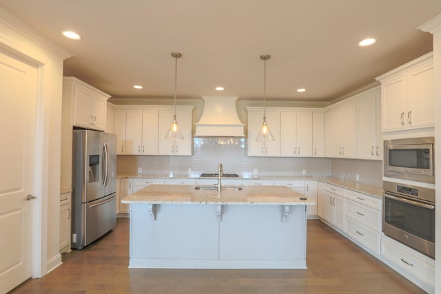 1023 Echelon Dr, Franklin, TN 37064 - kitchen featuring appliances with stainless steel finishes, custom exhaust hood, white cabinets, a breakfast bar area, and recessed lighting
