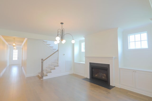 1023 Echelon Dr, Franklin, TN 37064 - unfurnished living room with ornamental molding, wood finished floors, healthy amount of natural light, stairway, and a decorative wall